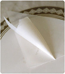 Tillverka en liten pappersstrut av ett trekantigt smörpapper.